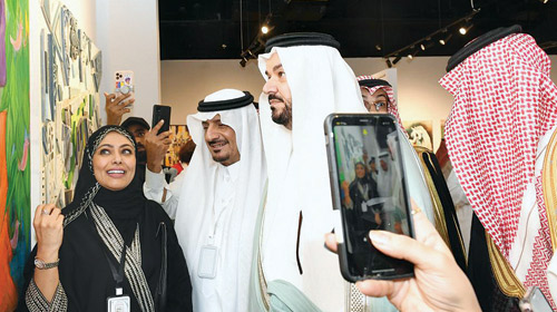 الأمير مشعل يستمع لشرح من إحدى الفنانات المشاركات